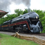 The Class J #611 passes the old passenger depot at The Plains