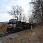 NS 228 climbs Linden Hill at the scenic Fiery Run Road crossing led by ES-44DC #7700 on 3/8/2017.