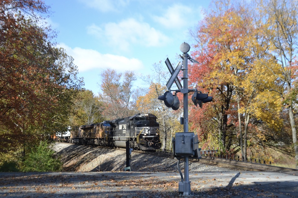 NS SD70IAC 1228 leads train NS 25a past some fall colors at the Fiery Run Road crossing at Belle Meade, VA on 10/24/2022.