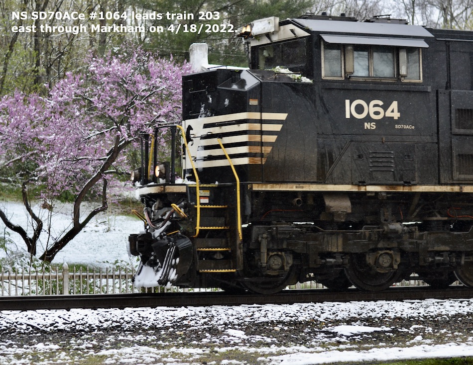NS SD70ACe #1064 with a redbud tree in a snowy scene on 4/18/2022.