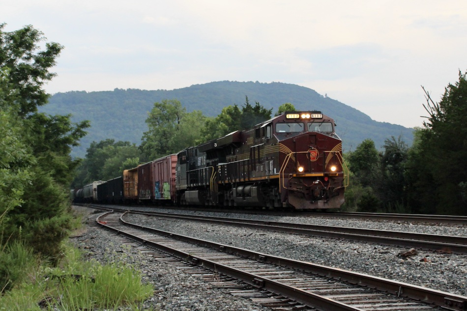 A specially painted Norfolk Southern heritage unit honoring the Pennsylvania Railroad leads a train through a scenic part of Virginia.