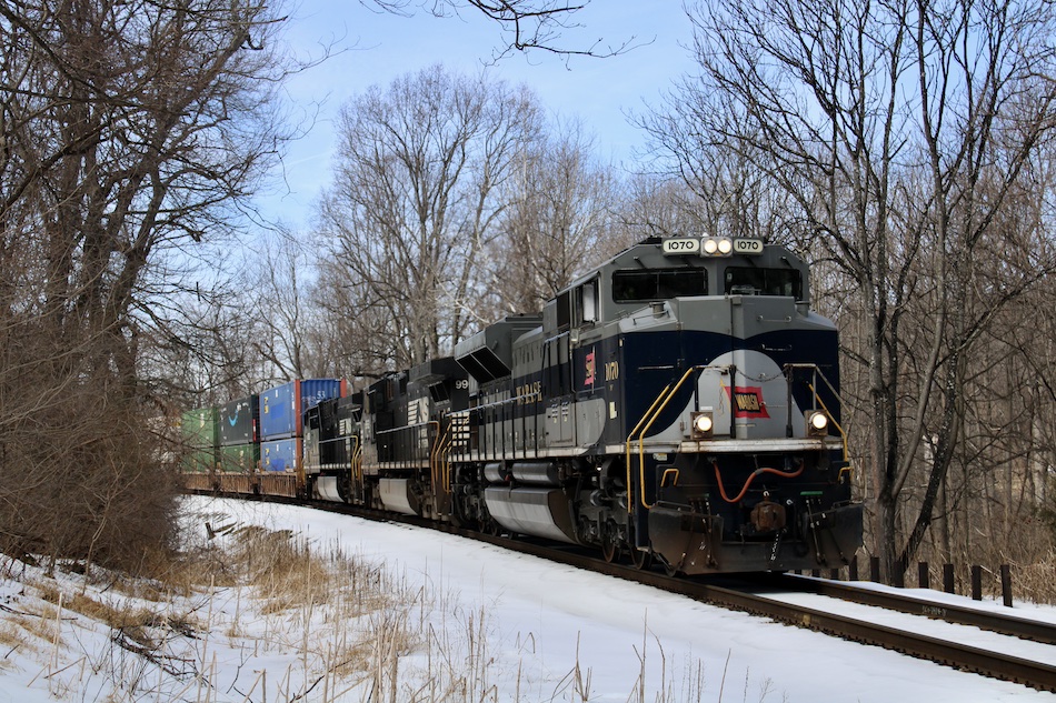 A specially painted Norfolk Southern  locomotive in the Wabash Railroad paint scheme leads train 25A with snow on the ground.