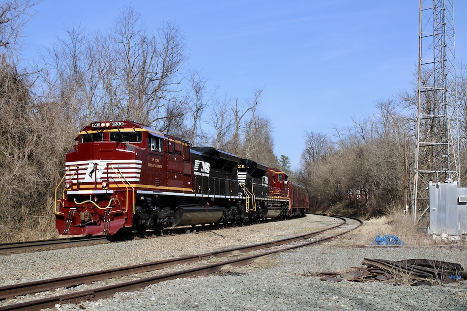 Two specially painted crimson and black locomotives named Birmingham and Atlanta lead a Norfolk Southern office car special under blue skies in Virginia.